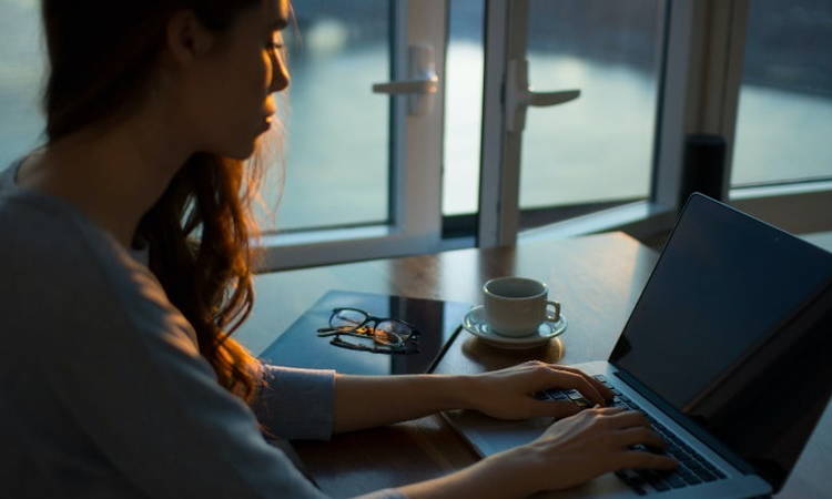 Woman Sending Email on Laptop at Desk