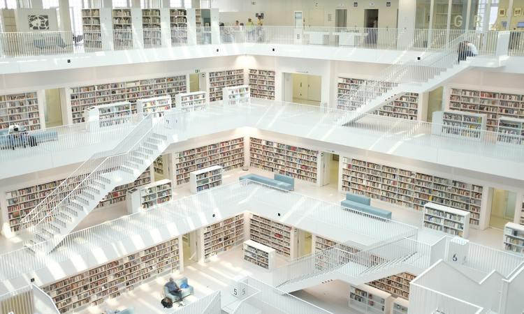 Seeking books in white library with four stories